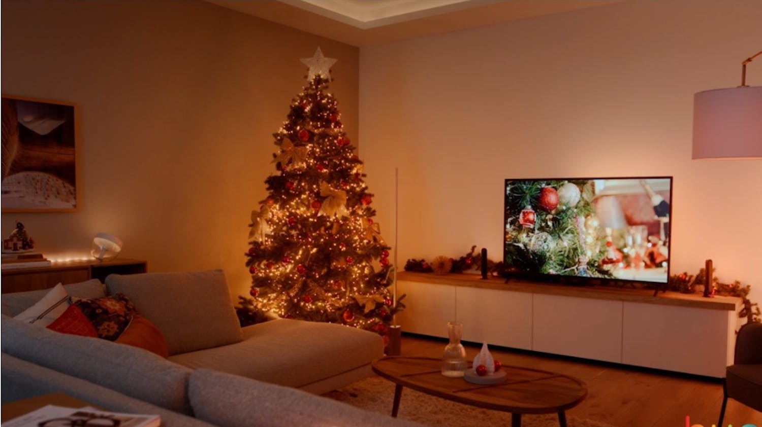 Philips Hue Signe: Smarte julelys på et juletre i en vakkert belyst stue.